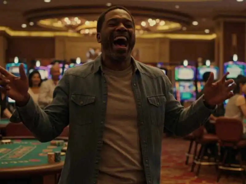 Man celebrating with arms raised after a thrilling Sports betting win at the casino